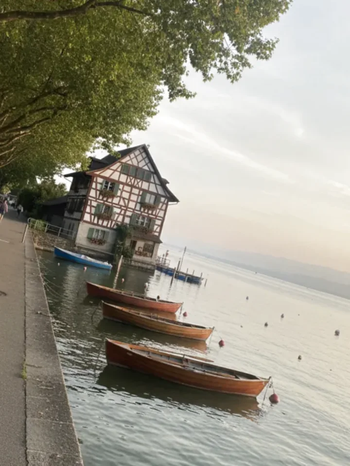 Seepromenade am Bodensee im Thurgau mit hölzernen Ruderbooten und einem Riegelhaus am Wasser – ReparFix vermittelt Glaskratzer-Entfernungen an Partnerbetriebe in Thurgau, die vor Ort polieren.