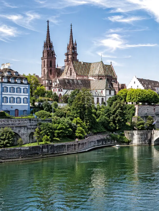 Basler Münster mit den roten Türmen über dem Rhein und der Mittleren Brücke – ReparFix vermittelt Lavabo-Reparaturen an Partnerbetriebe in Basel, die vor Ort reparieren.